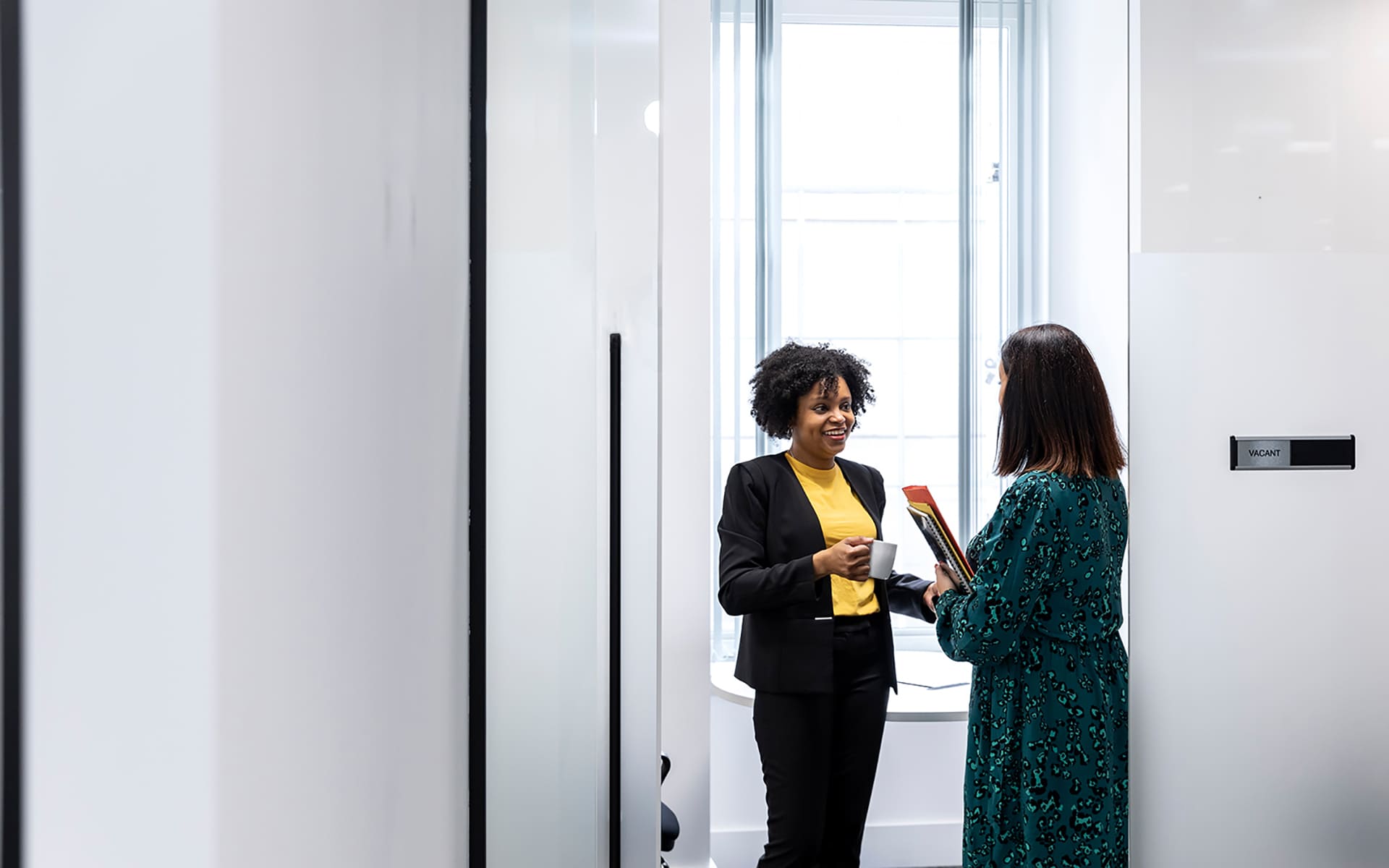 Two businesswomen talking in a modern office