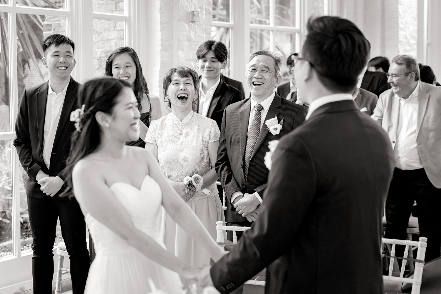 Bride and groom laughing with guests at a wedding ceremony