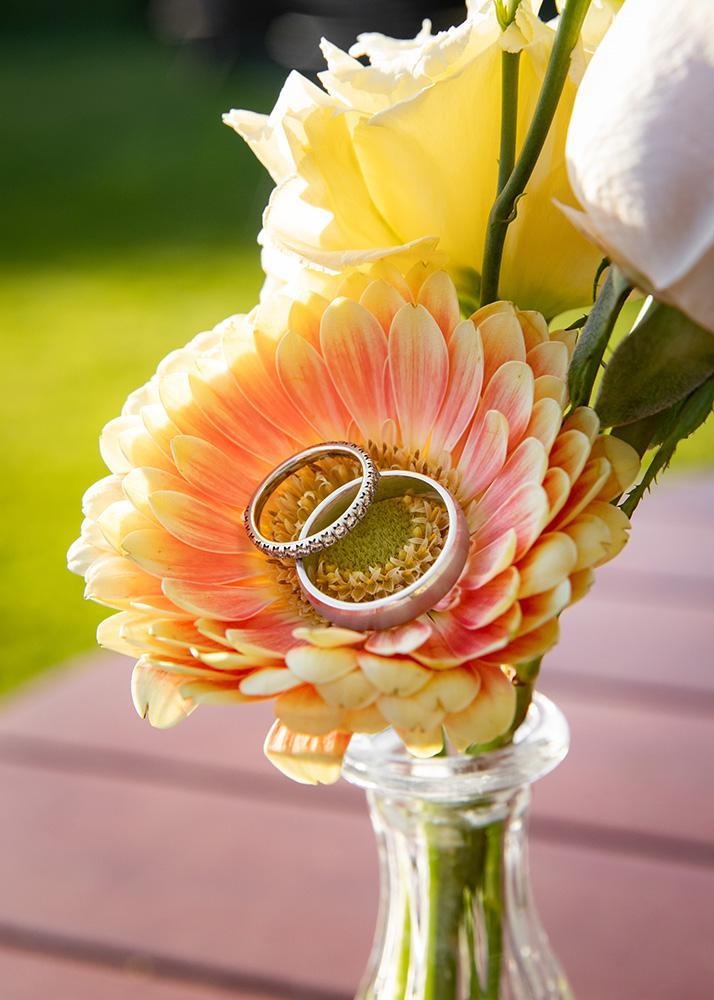 Wedding rings placed on a colourful flower bouquet