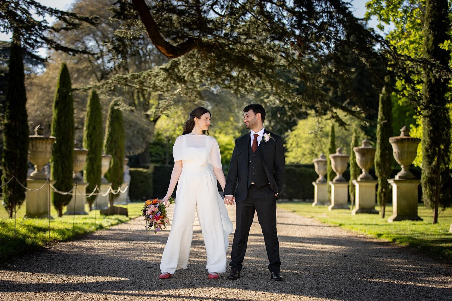 Wedding couple holding hands during a garden portrait session