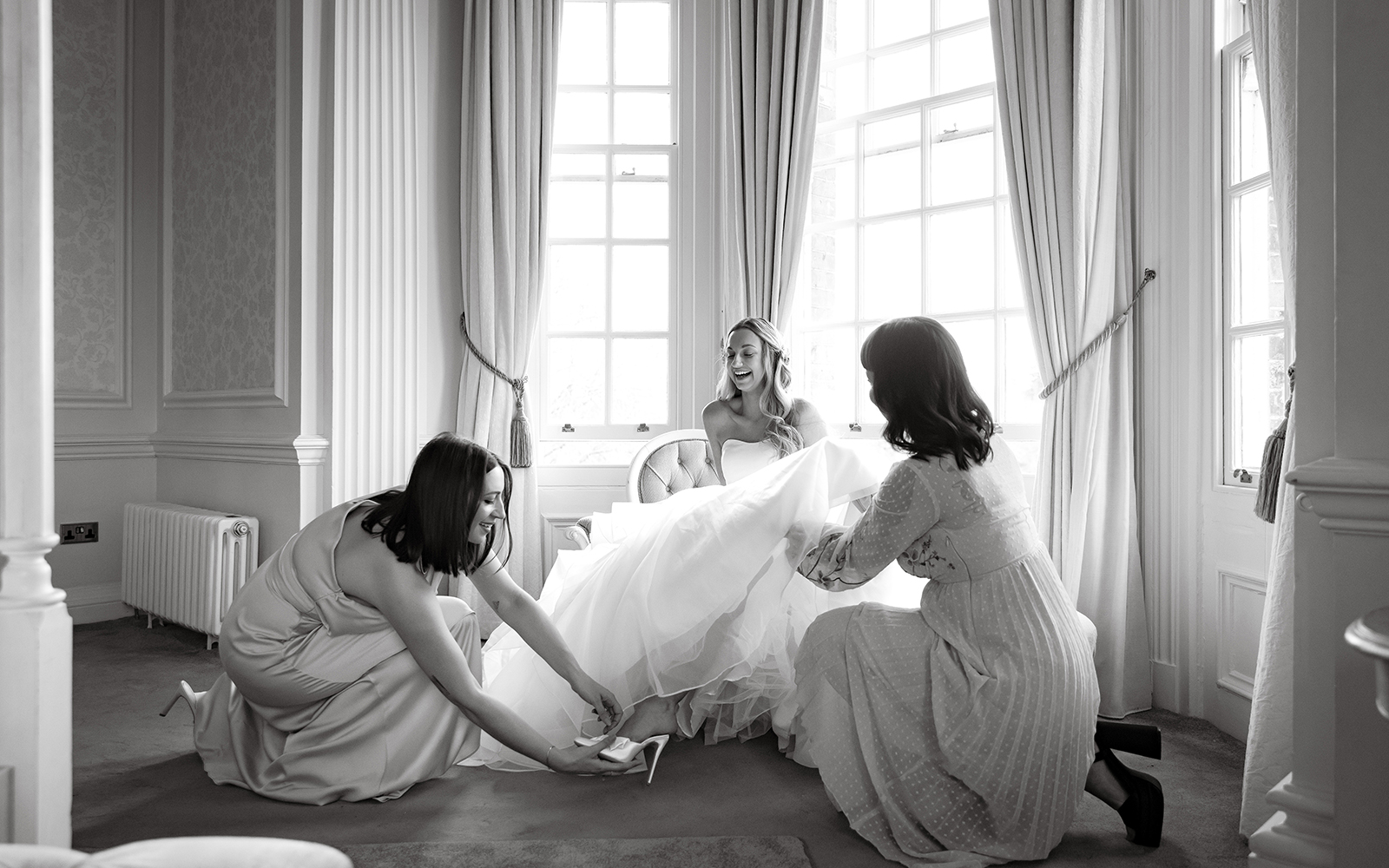 Bride getting ready with bridesmaids in an elegant room before her wedding ceremony in London.